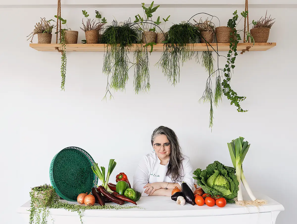 Chef preparado con verduras frescas y utensilios de cocina.